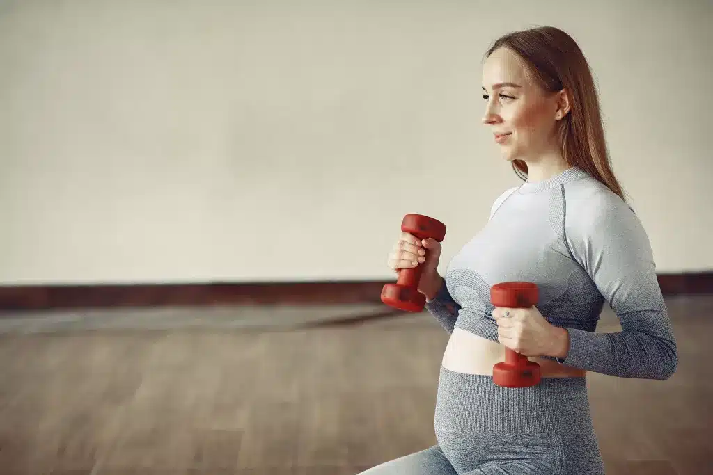 Pregnant girl in a gym. Sports girl in a sportswear.